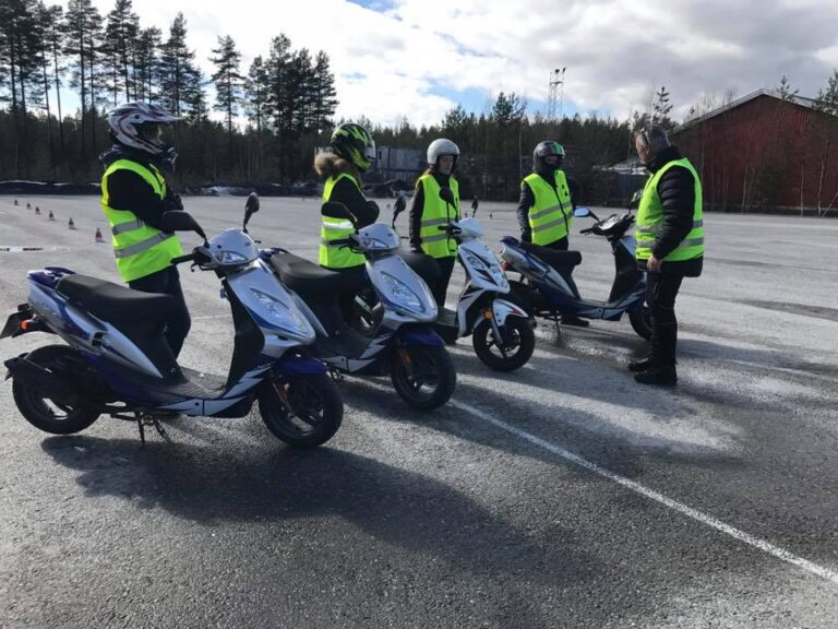 Trafikkskolelærer som har opplæring på moped med 4 elever ute på øvingsbane